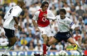 Arsenal's Robert Pires (C) is challenged