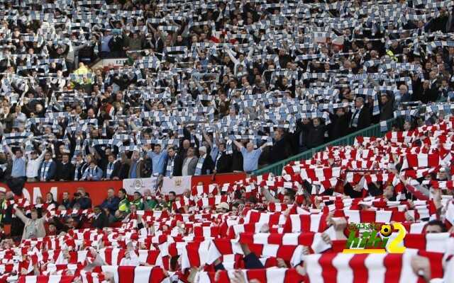 Manchester United and Manchester City fans hold scarves during a minute's silence to mark 50th anniversary of the Munich air disaster in Manchester...Manchester United and Manchester City fans hold scarves during a minute's silence to mark the 50th anniversary of the Munich air disaster before their English Premier League soccer match in Manchester, northern England February 10, 2008.   REUTERS/Darren Staples   (BRITAIN).  NO ONLINE/INTERNET USAGE WITHOUT A LICENCE FROM THE FOOTBALL DATA CO LTD. FOR LICENCE ENQUIRIES PLEASE TELEPHONE +44 (0) 207 864 9000.